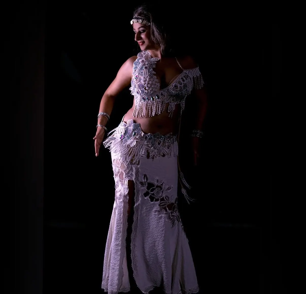 Alexandra in an ivory beaded costume with an ornate headpiece, full-length editorial portrait
